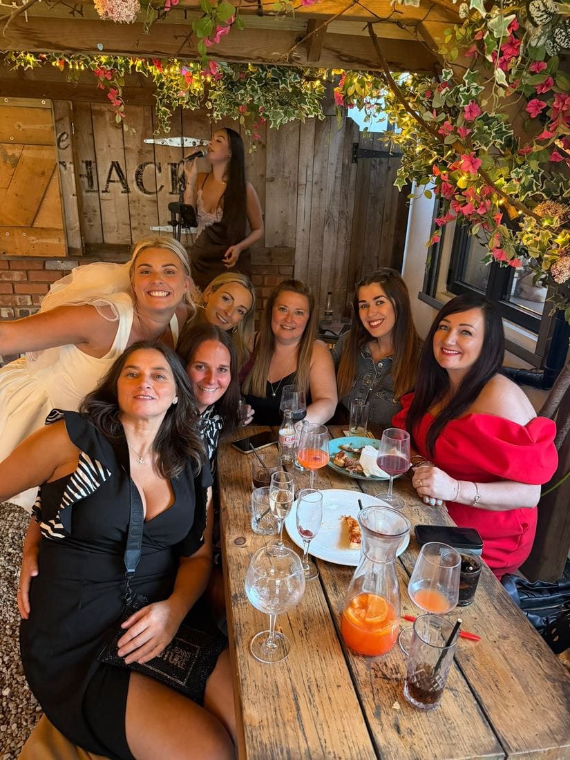 Guests celebrating together under the pergola's fairy lights and flowers