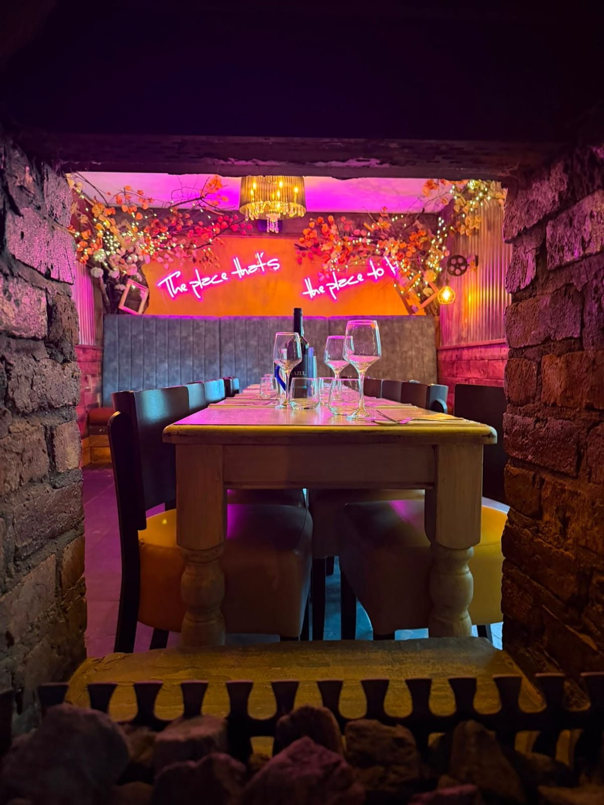 Semi-private dining for up to 20 guests, with the neon “The place that’s the place to be” sign