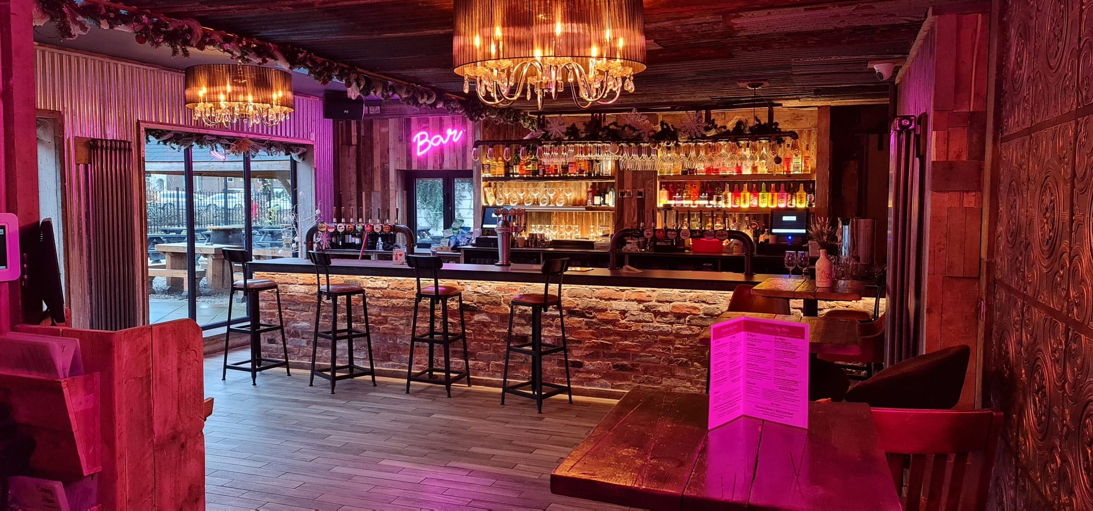 The bar at Waterside, warm lighting over reclaimed brick and glassware